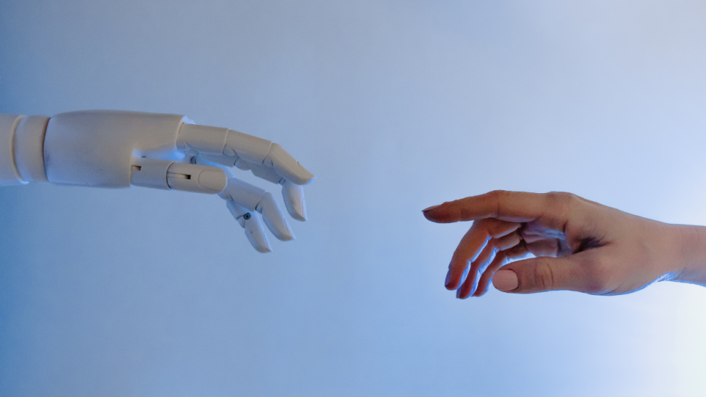左からロボットの手、右から人間の手が伸びてきている画像